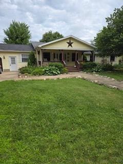 view of front of home featuring covered porch and a front yard