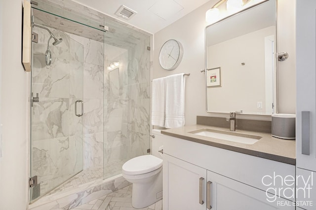 bathroom with vanity, toilet, and a shower with shower door