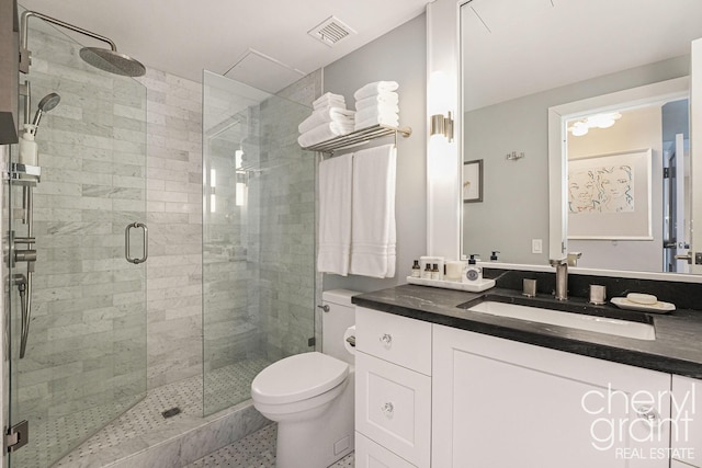 bathroom featuring vanity, an enclosed shower, and toilet