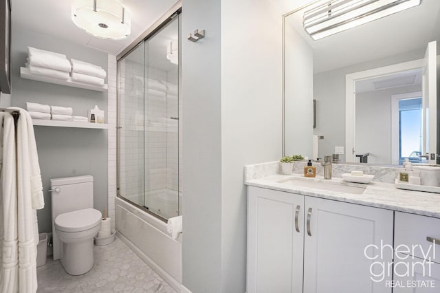 full bathroom with vanity, toilet, and bath / shower combo with glass door