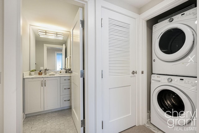 washroom featuring stacked washer / drying machine and sink