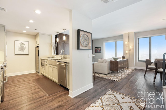 kitchen with pendant lighting, sink, dark wood-type flooring, and appliances with stainless steel finishes