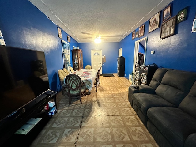 living room with ceiling fan and a textured ceiling