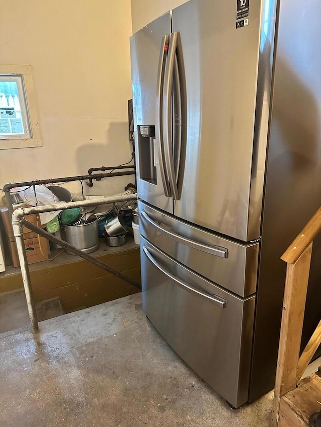 kitchen with stainless steel fridge with ice dispenser and concrete floors