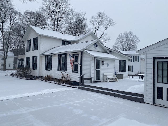 view of snow covered rear of property