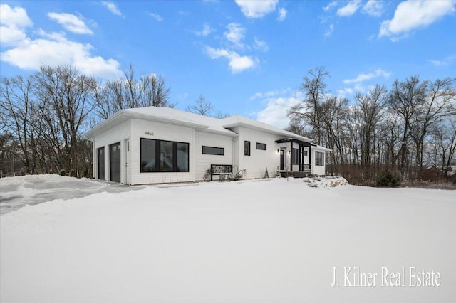 snow covered property featuring a garage