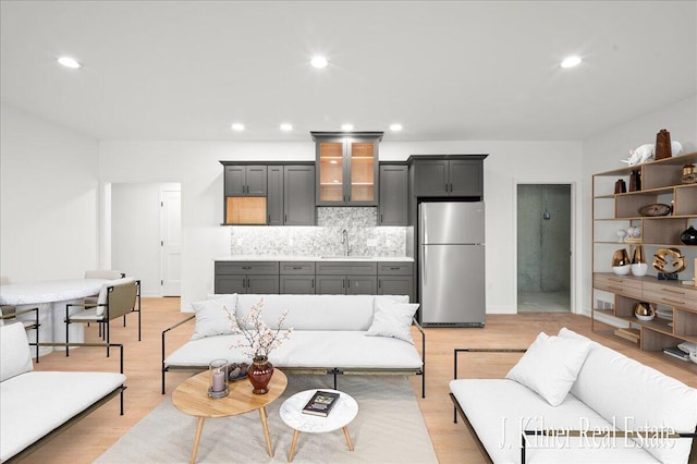 living room featuring sink and light hardwood / wood-style floors