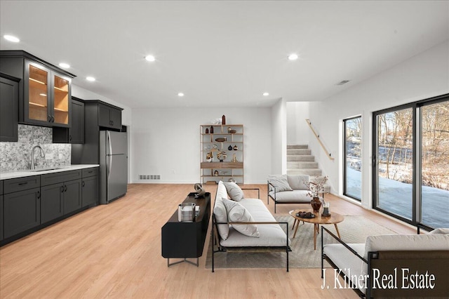 living room with sink and light hardwood / wood-style flooring