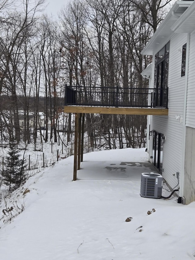 snow covered deck featuring central air condition unit