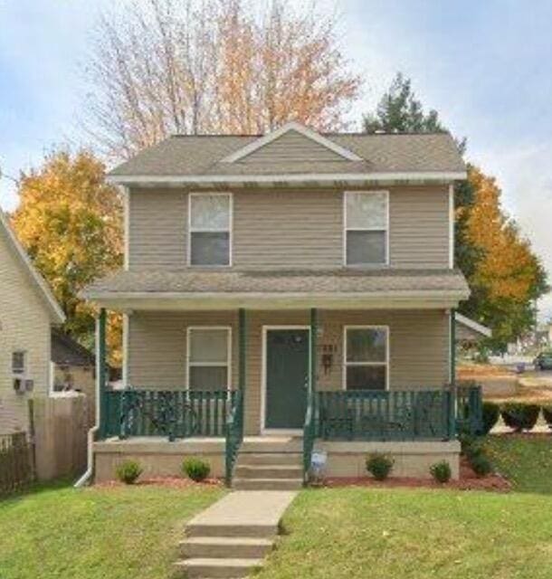 view of front property featuring covered porch and a front lawn