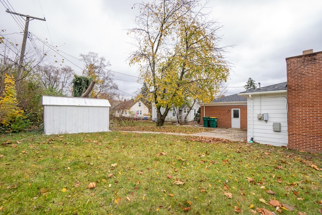 view of yard with a storage shed and a patio