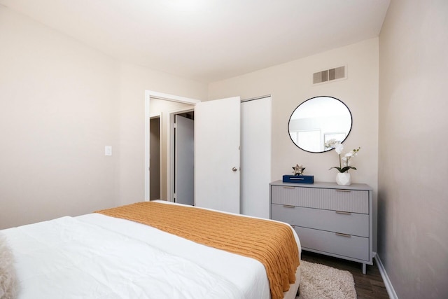 bedroom with dark hardwood / wood-style flooring and a closet