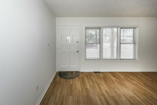 foyer featuring hardwood / wood-style flooring and a textured ceiling