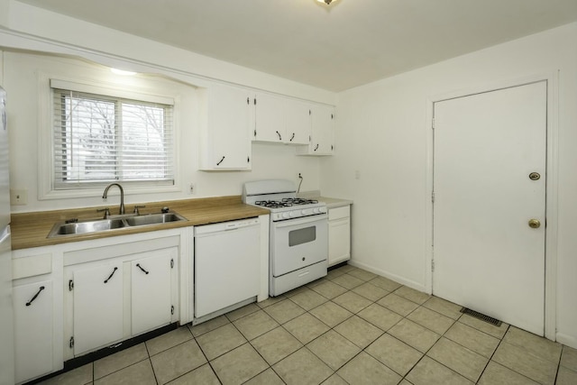 kitchen with sink, white appliances, white cabinetry, and light tile patterned floors