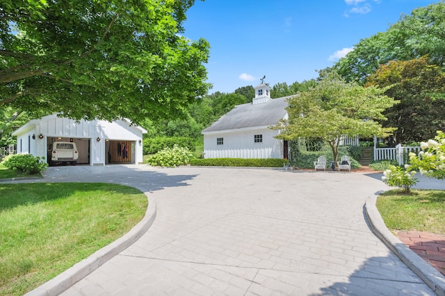 exterior space featuring a front lawn, an outdoor structure, and a garage