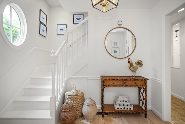 staircase featuring hardwood / wood-style floors and a notable chandelier