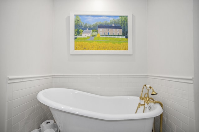 bathroom with a washtub and tile walls