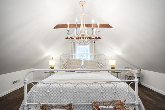 bedroom with dark hardwood / wood-style floors, lofted ceiling, and an inviting chandelier