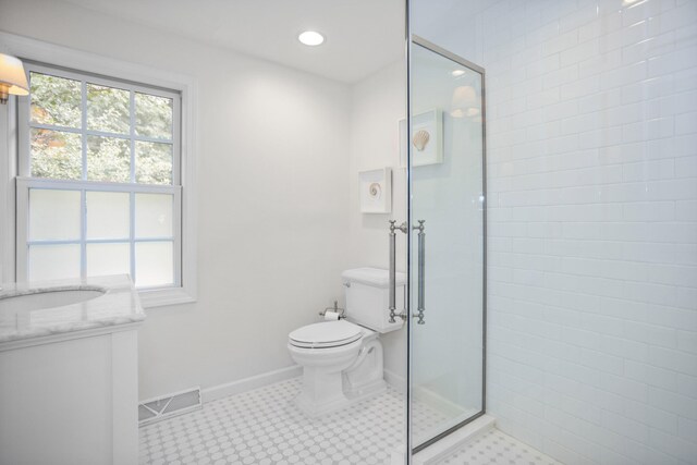 bathroom with vanity, toilet, and a shower with shower door