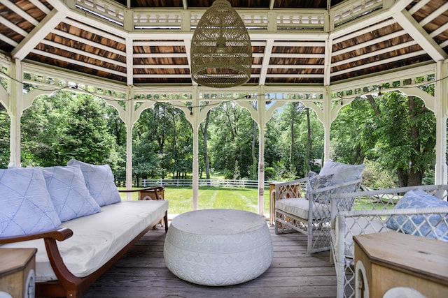 wooden deck featuring a gazebo, an outdoor hangout area, and a lawn