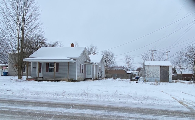 snow covered property featuring a shed