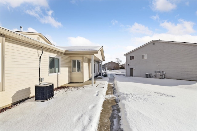 view of snowy exterior with cooling unit