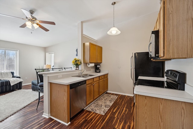 kitchen with appliances with stainless steel finishes, hanging light fixtures, kitchen peninsula, dark hardwood / wood-style flooring, and sink