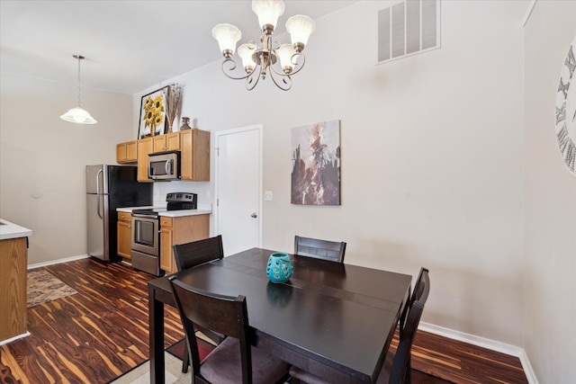 dining area with dark wood-type flooring and a chandelier