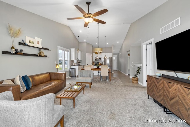 living room with light carpet, ceiling fan, and lofted ceiling