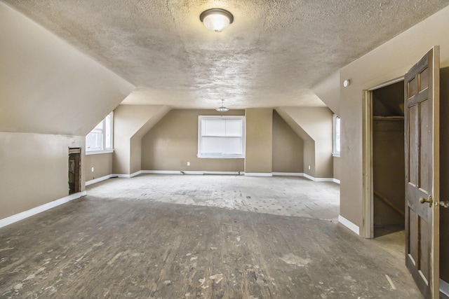 bonus room featuring lofted ceiling and a textured ceiling