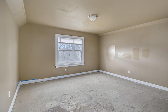 spare room featuring lofted ceiling