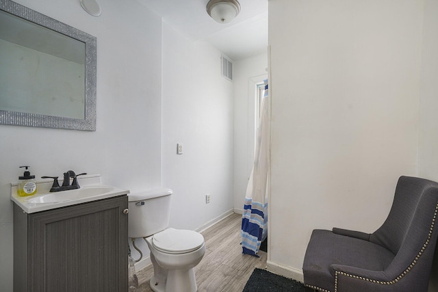 bathroom featuring toilet, vanity, and hardwood / wood-style floors