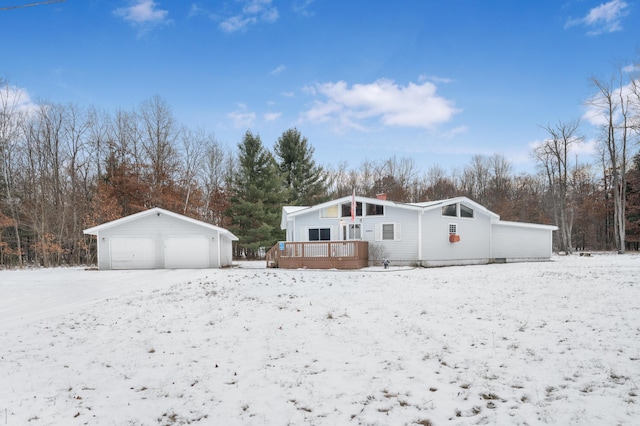 exterior space featuring a garage, an outbuilding, and a wooden deck