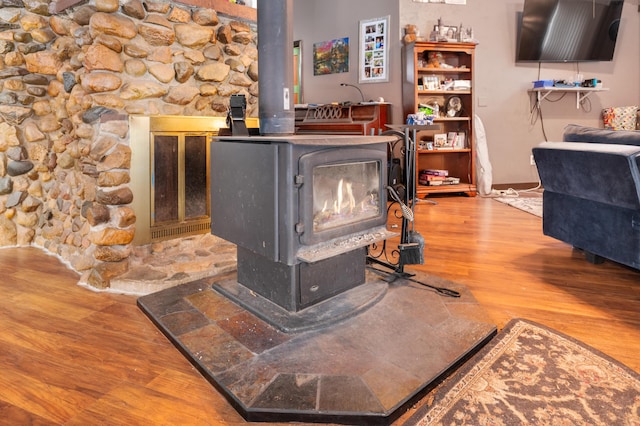 details featuring a wood stove and hardwood / wood-style floors