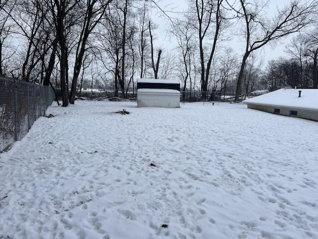 snowy yard with a storage shed