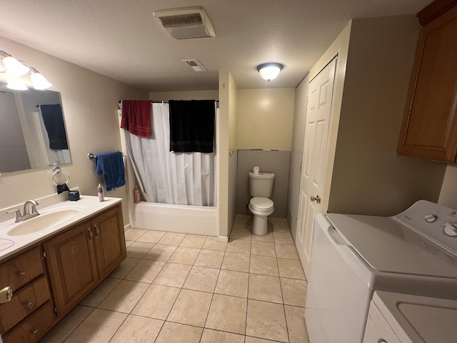 full bathroom featuring tile patterned floors, vanity, a textured ceiling, washing machine and dryer, and toilet