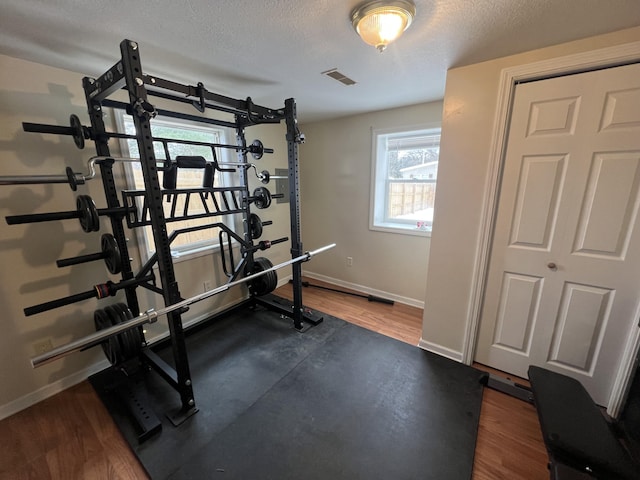 exercise area featuring dark hardwood / wood-style flooring and a textured ceiling