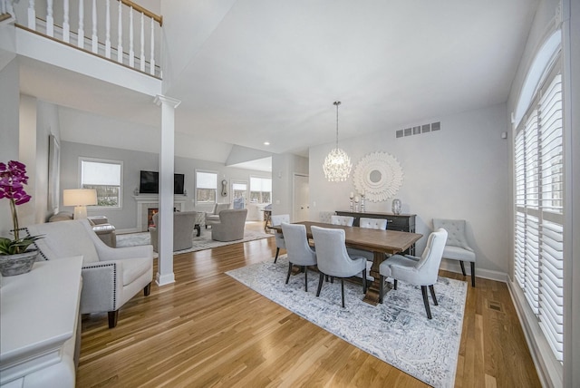 dining space featuring vaulted ceiling, wood-type flooring, and a chandelier