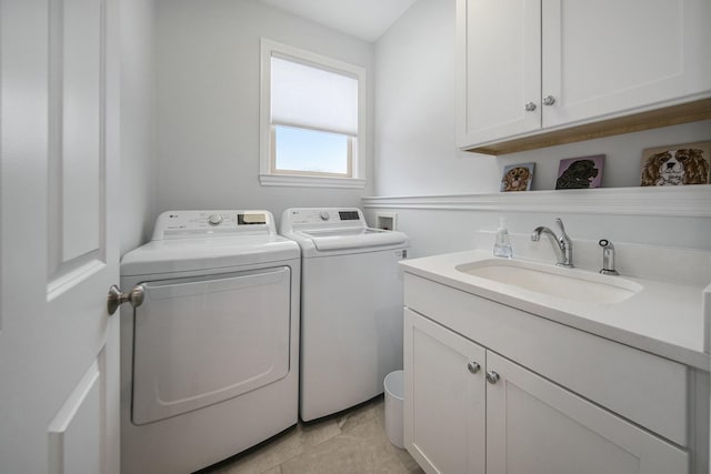 washroom with cabinets, independent washer and dryer, sink, and light tile patterned floors