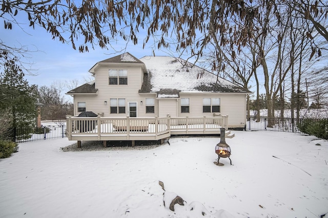 snow covered house with a deck