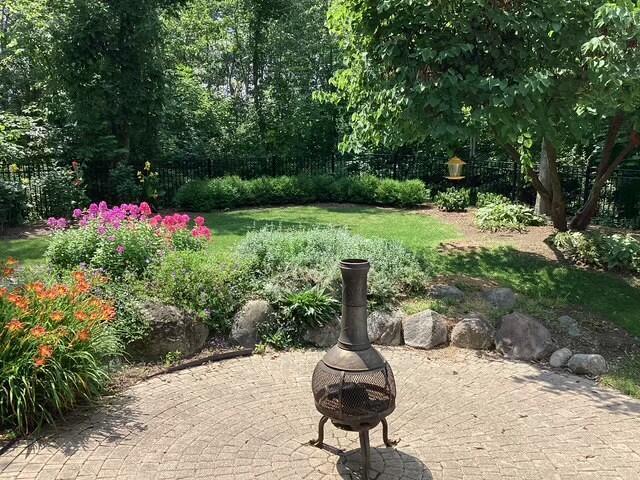 view of property's community featuring a patio area and an outdoor fire pit