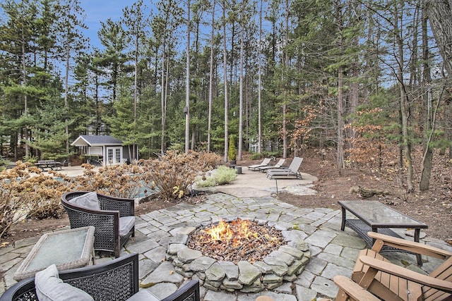 view of patio / terrace featuring a fire pit and an outbuilding