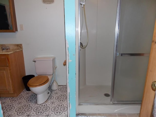 bathroom featuring tile patterned flooring, an enclosed shower, vanity, and toilet