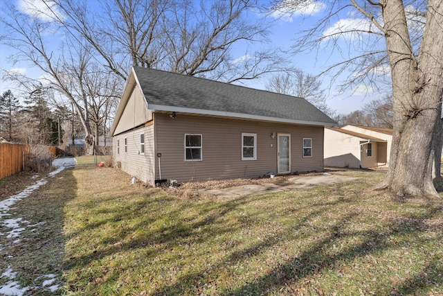 rear view of property featuring a lawn