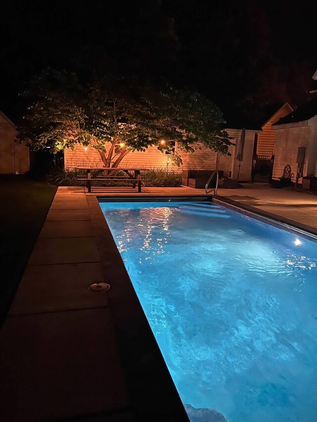 pool at twilight with a patio