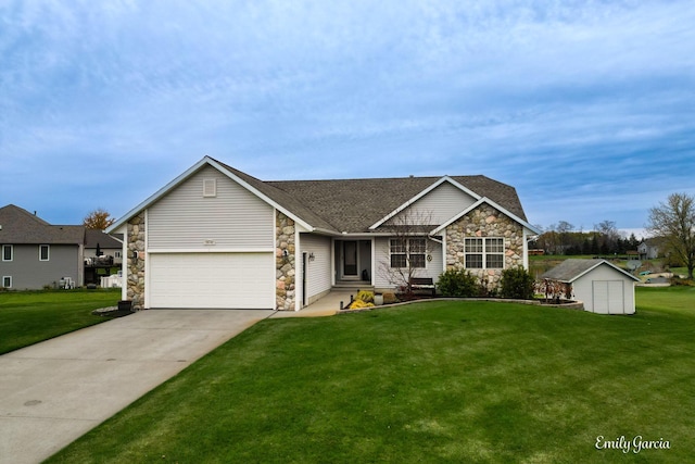 view of front of property featuring a front yard, a storage unit, and a garage