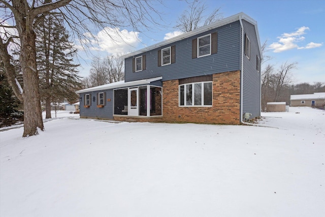 view of snow covered back of property