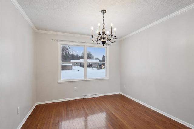 spare room with a textured ceiling, hardwood / wood-style flooring, crown molding, and an inviting chandelier