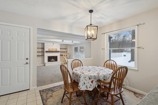 tiled dining room featuring a textured ceiling and a fireplace