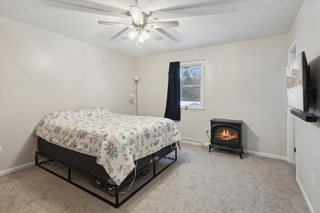 bedroom featuring a textured ceiling, light colored carpet, and ceiling fan